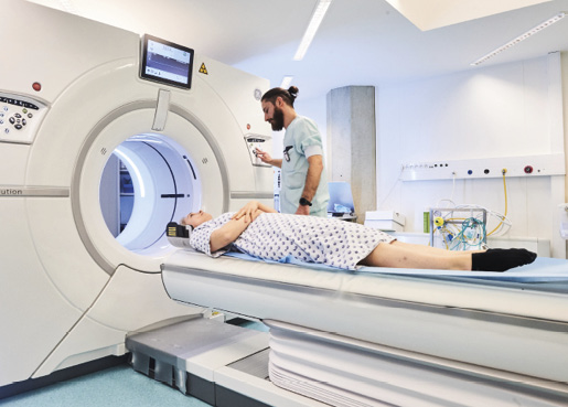 Un profesional sanitario realiza un examen de imagen por resonancia magnética a un paciente.