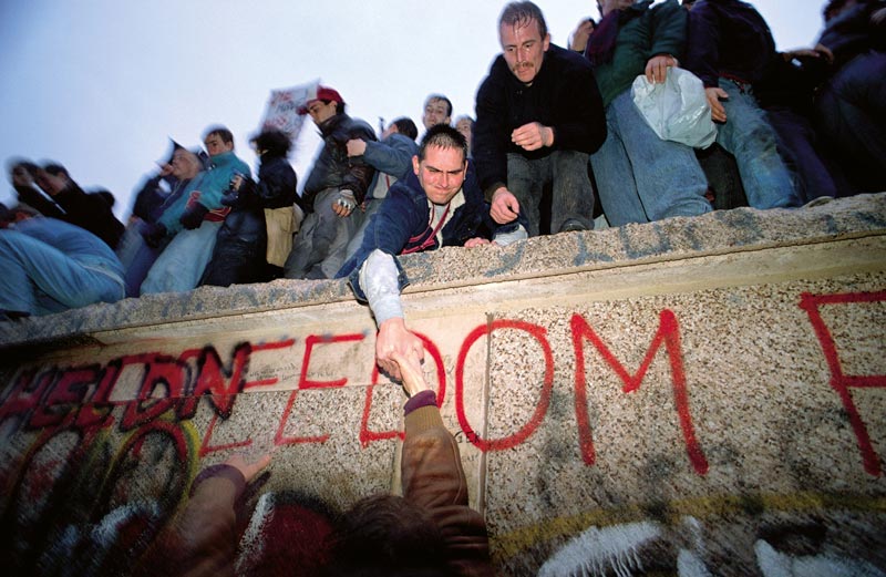 Jasajúci dav na Berlínskom múre v deň jeho pádu.
