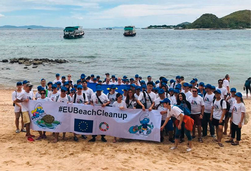 Skupina ljudi na plaži s transparentom European Union Beach Clean-up (čiščenje obale pod okriljem Evropske unije)