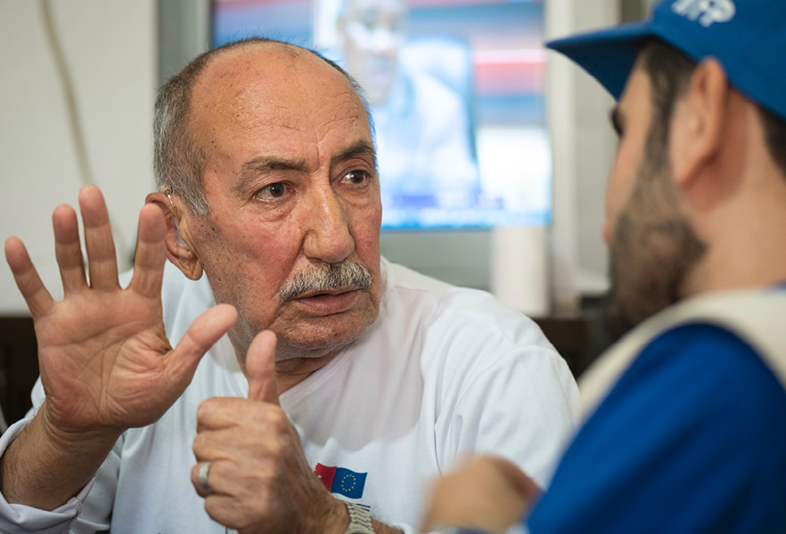 Vieil homme en conversation avec un travailleur humanitaire.