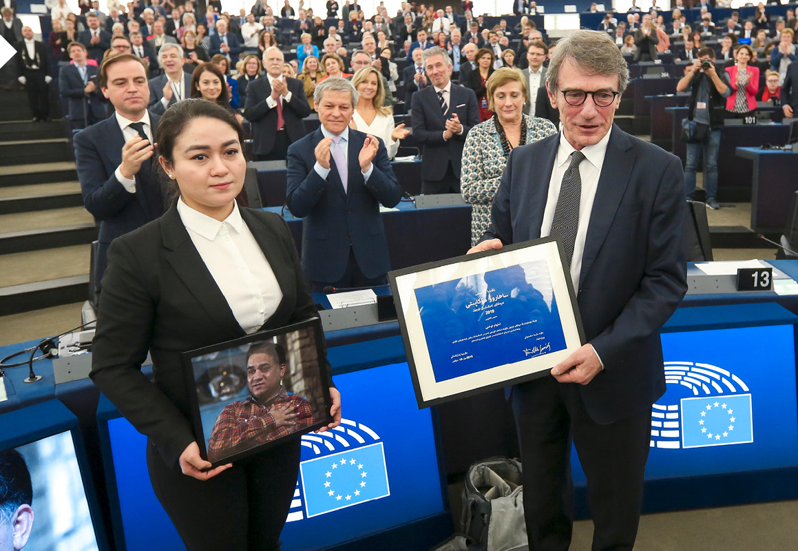 Jewher Ilham portant une photo de son père se voit présenter par David Sassoli le prix Sakharov obtenu par son père.