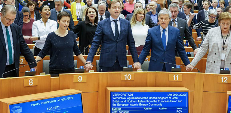 Des députés du Parlement européen debout et main dans la main dans l’enceinte du Parlement.